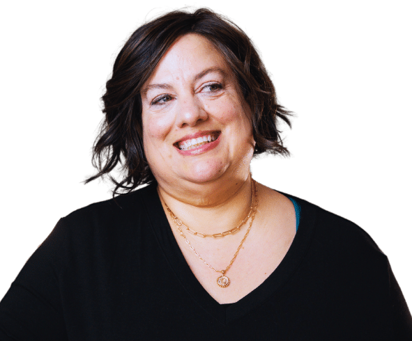 Close-up portrait of North Carolina real estate agent Dorathea Schultes smiling against a dark background.