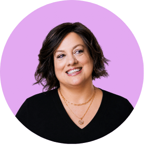 Circular headshot portrait of North Carolina real estate agent Dorathea Schultes on a purple background.